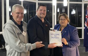 President Julie Irwin and Rotarian Stewart Cummings, welcome new member Michael Schubert to Rotary Victor Harbor.